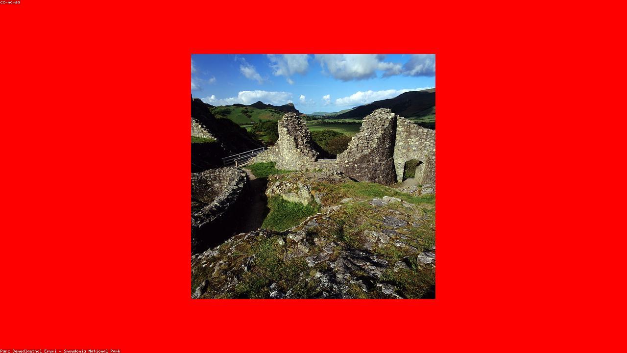 Castell y Bere ruins on a rocky ridge in the green Dyfi Valley, with mountain slopes rising on all sides and Cadair Idris visible to the north
