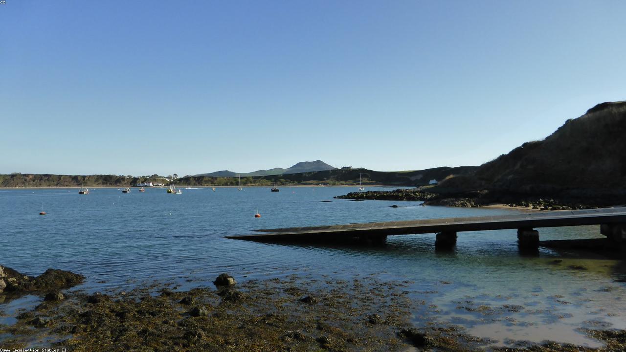 Calm blue water at Nefyn Beach with the Llŷn hills beyond