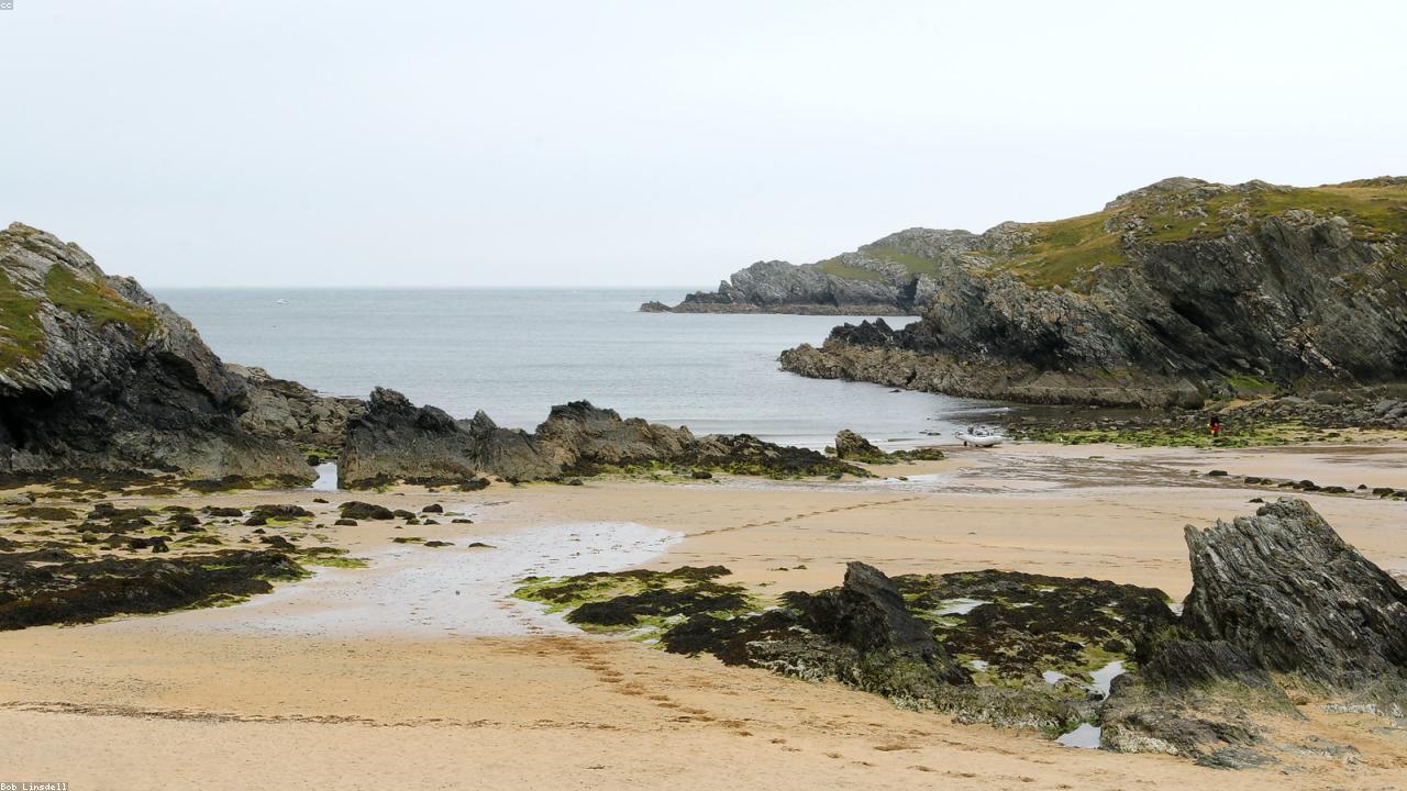 Porthdafarch rocky cove on Holy Island with clear water and the Anglesey coast beyond
