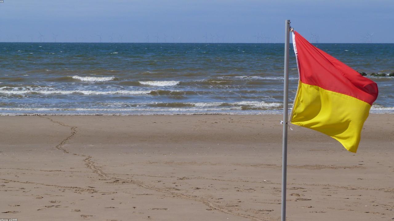 Golden sands of Prestatyn Beach stretching along the North Wales coast with blue sea